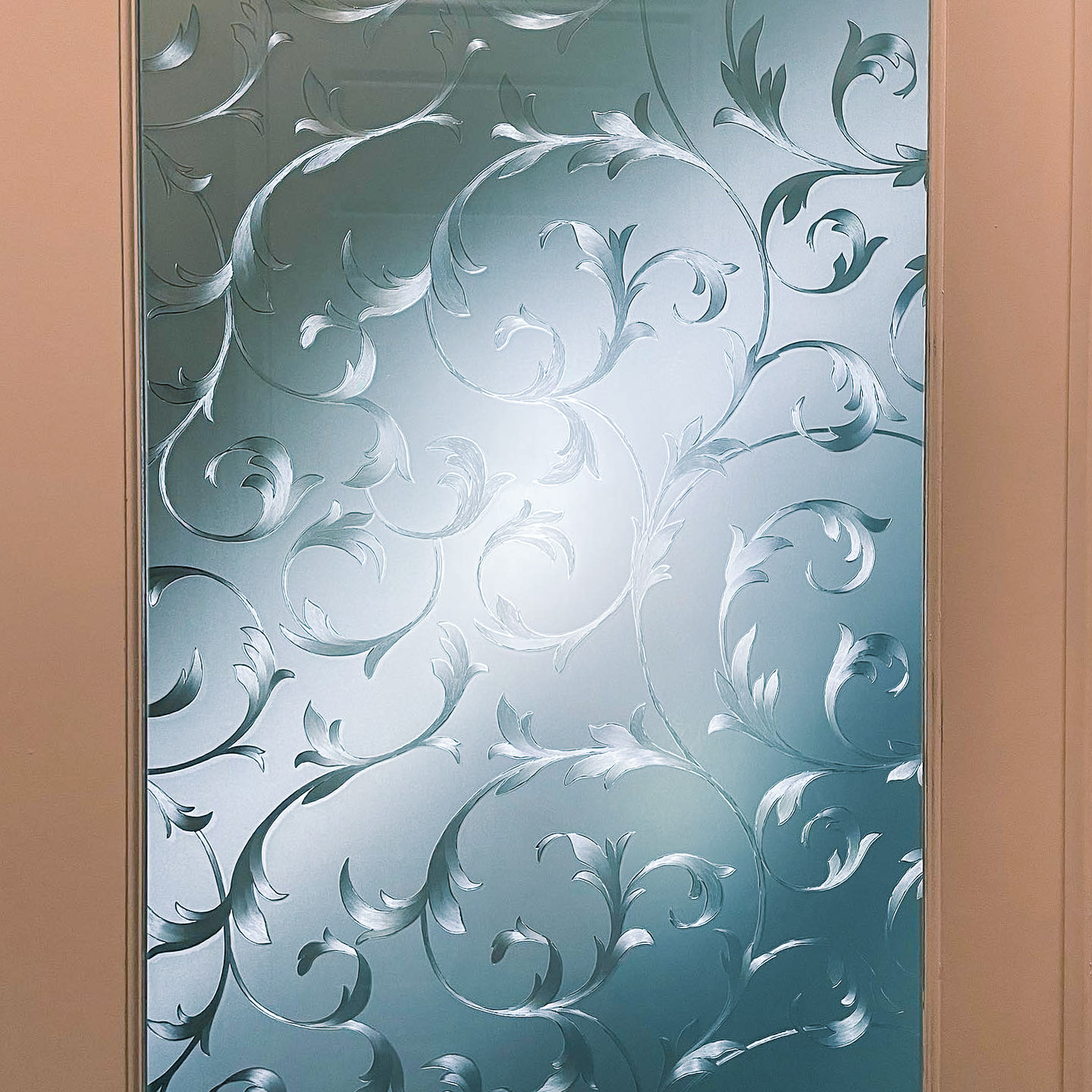 Close-up of decorative window film with an elegant swirl design